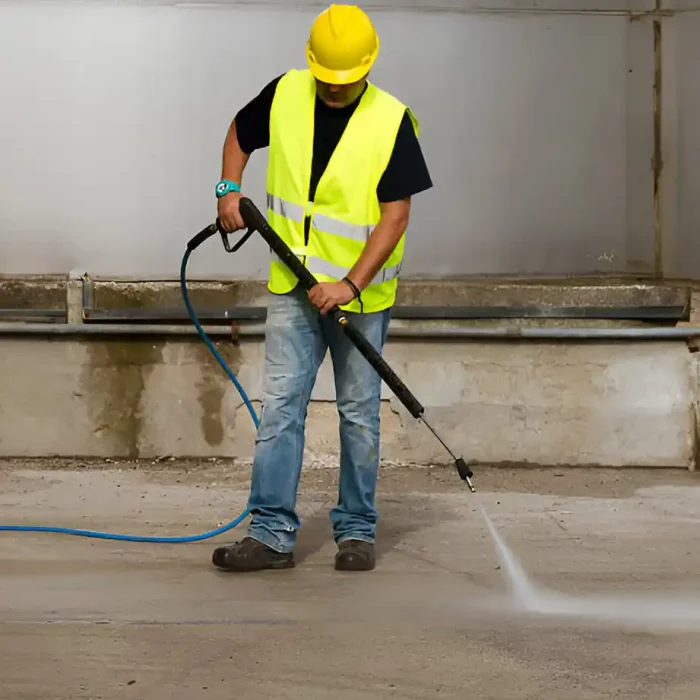 Ein Arbeiter mit gelber Weste und Schutzhelm verwendet einen Hochdruckreiniger in Reutlingen
