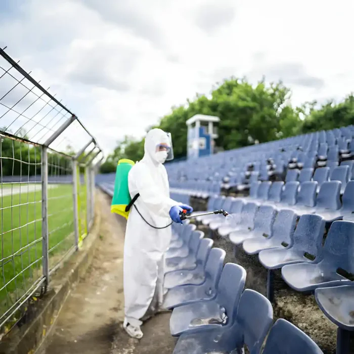 Arbeiter in Schutzkleidung bei der Desinfektion von Sitzen in einem Stadion mit einem Sprühgerät in Reutlingen