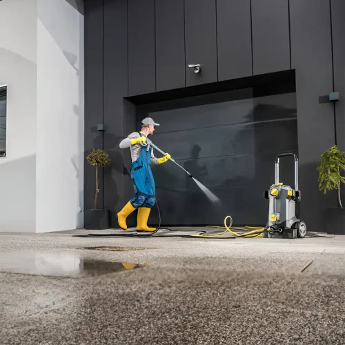 Fachmännische Reinigungskraft in Schutzkleidung beim Reinigen von Fensterläden mit einer modernen Wasserpumpe