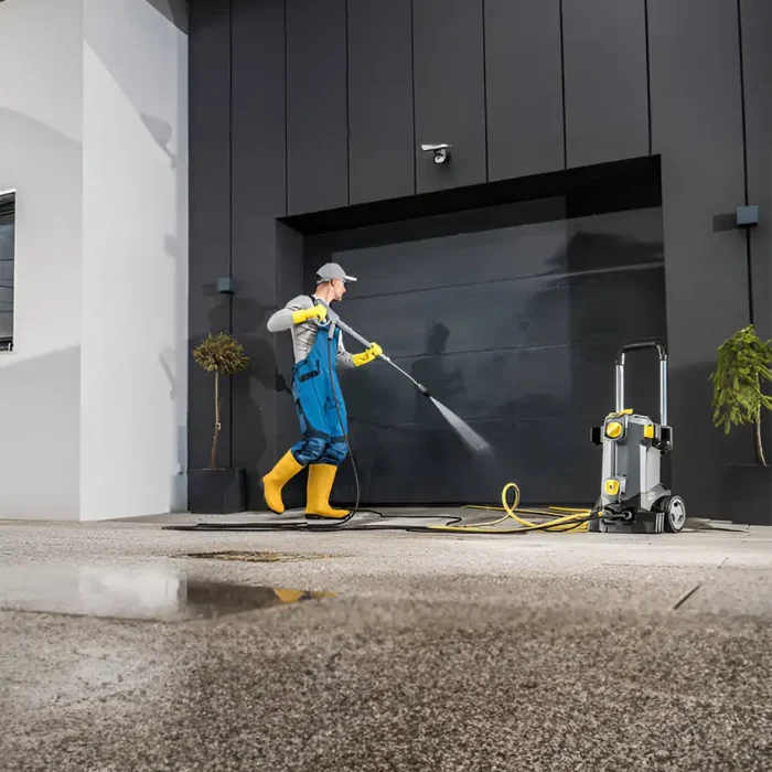 Fachmännische Reinigungskraft in Schutzkleidung beim Reinigen von Fensterläden mit einer modernen Wasserpumpe