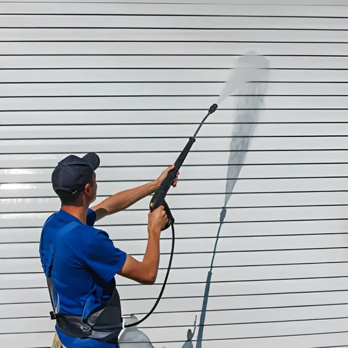 Professionelle Reinigung eines weißen Fensterladens mit einem Hochdruckreiniger