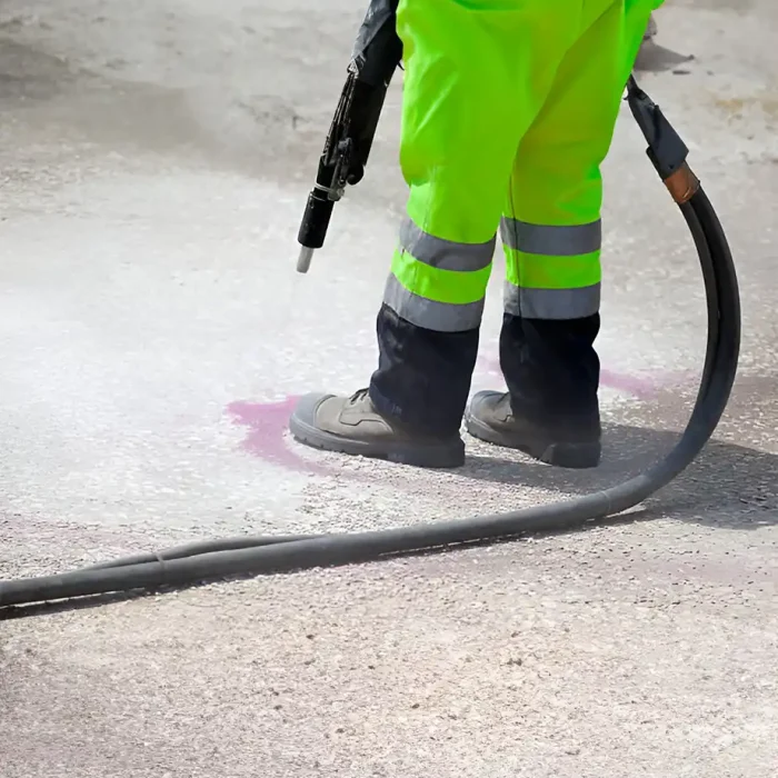 Arbeiter in fluoreszierender Kleidung beim Hochdruckreinigen einer Betonoberfläche in Albstadt