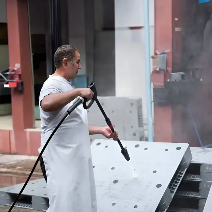 Ein Mann benutzt einen Hochdruckreiniger, um große Industrieflächen zu reinigen in Sinsheim