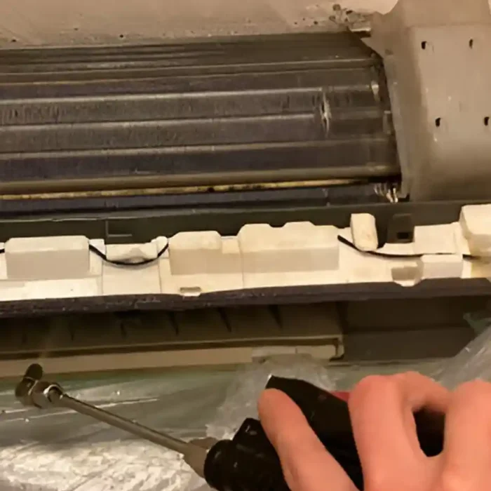 Nahaufnahme der Klimaanlage, die mit Luftdruck gereinigt wird