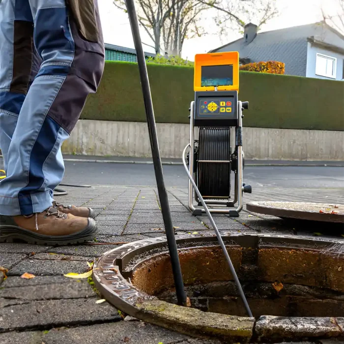 Techniker inspiziert unterirdische Rohre mit einem Kamerasystem