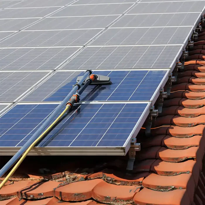 Reinigungsgeräte auf Solarmodulen positioniert, mit sichtbaren Wasserschläuchen