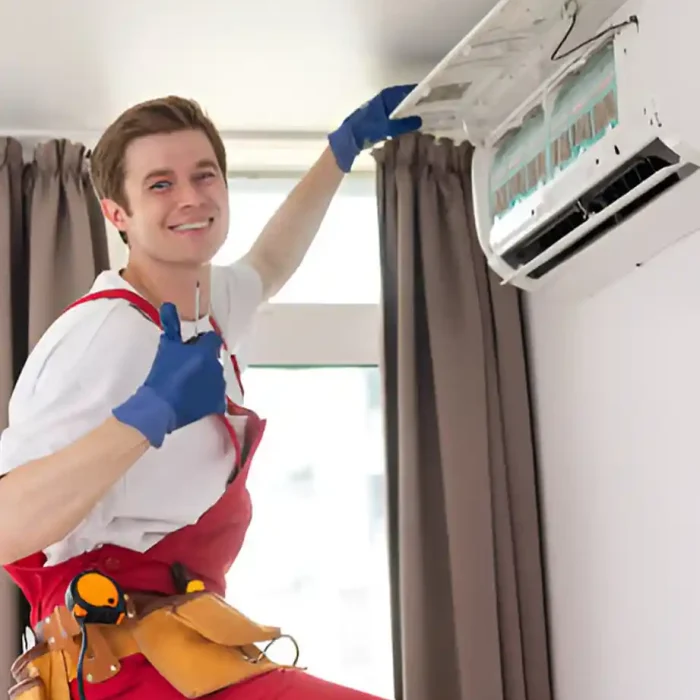 professioneller Reiniger, der das Gehäuse einer Klimaanlage nach perfekter Reinigung in die Höhe hält