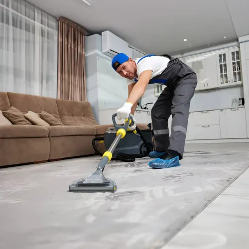 Reinigungsfachkraft posiert mit einem Staubsauger bei der Reinigung des Wohnbereichs einer Wohnung