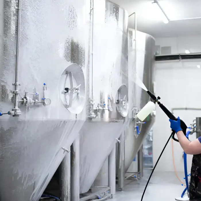Ein Arbeiter reinigt mit einem Hochdruckreiniger große Brauerei-Tanks aus Edelstahl in Recklinghausen