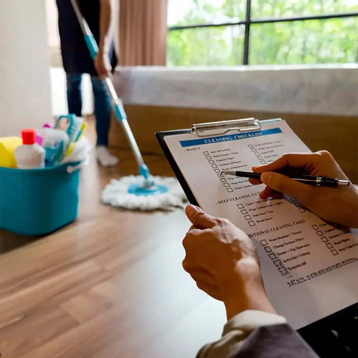 Vorgesetzter geht die Checkliste durch, während ein Mitglied den Boden wischt