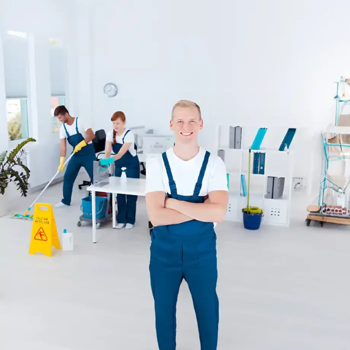 Lächelndes Reinigungsteam in blauen Uniformen arbeitet in einem hellen Büroraum in Reutlingen