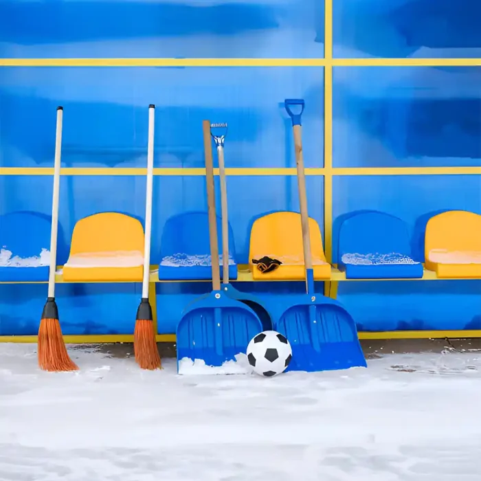 Reinigungsgeräte und ein Fußball neben bunten Bänken auf einem Sportplatz in Reutlingen