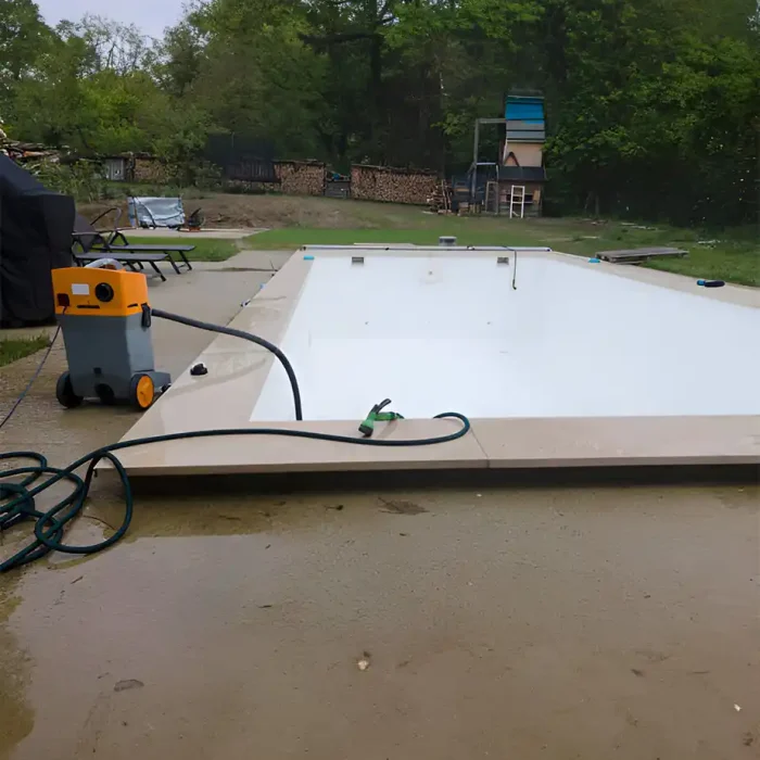Staubsauger am Pool neben einem leeren, sauberen Pool