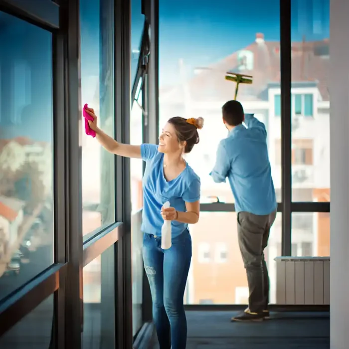 Zwei Personen reinigen große Fenster in einem hellen Raum in Einbeck