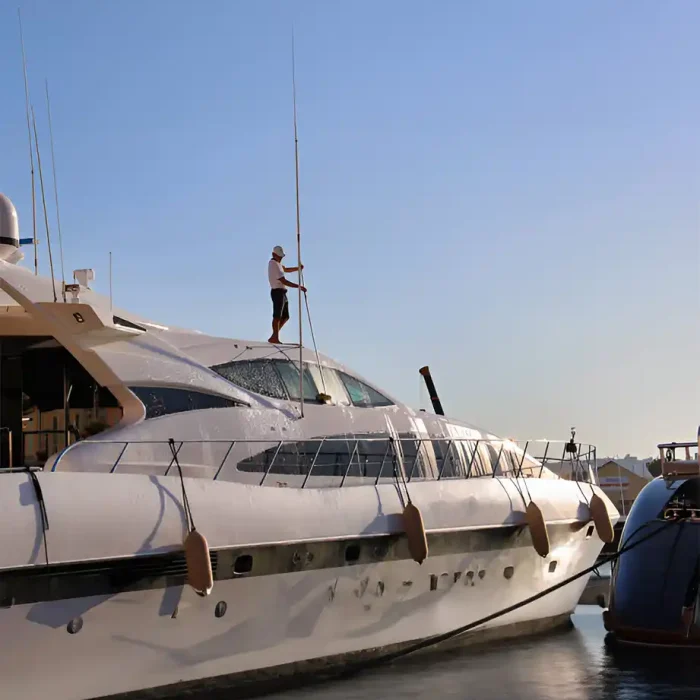 Arbeiter auf einer Yacht bei der Wartung mit einem klaren Himmel über dem Kopf